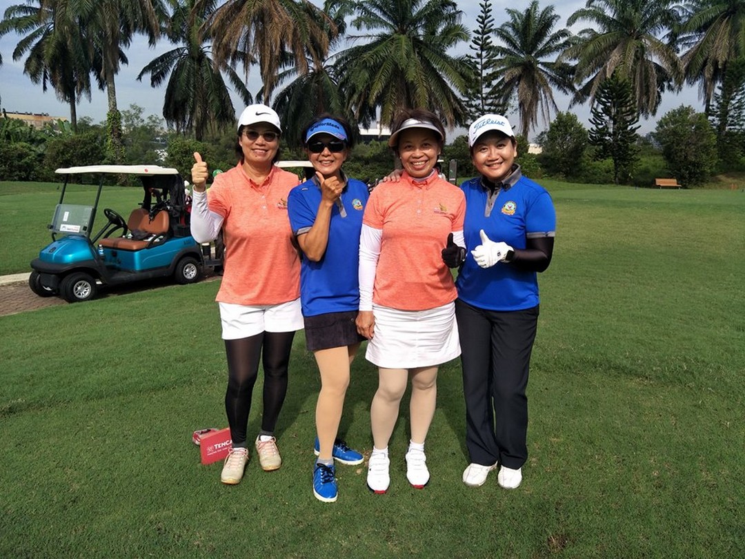 Group of ladies posing for a picture at the golf field