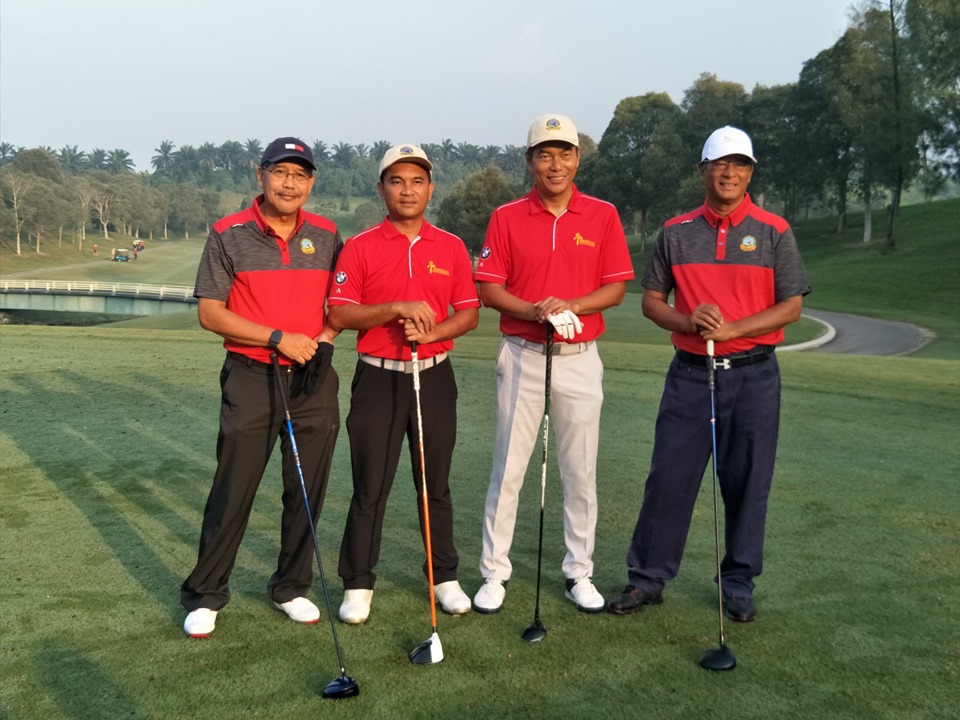 Four golfers smiling on the course