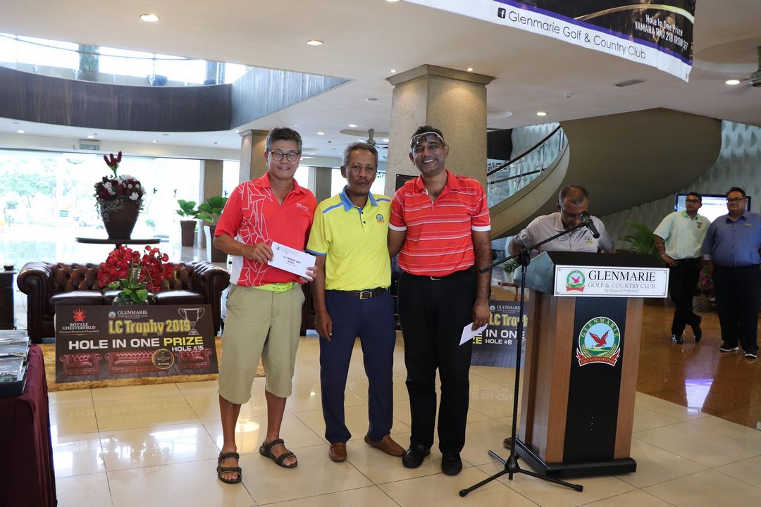 Three gentleman are holding their vouchers and posing for a photograph