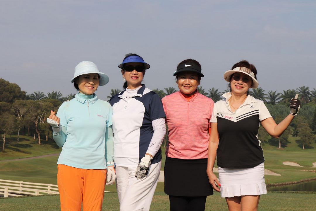 Group of ladies posing for a picture at the golf field