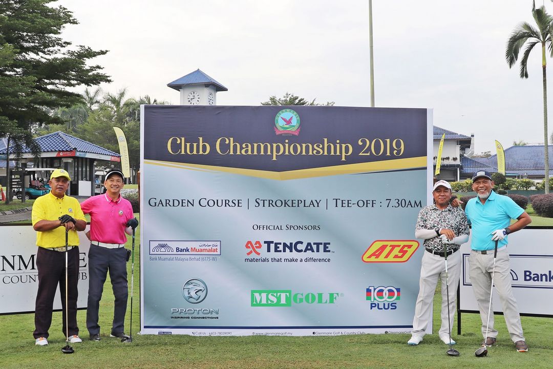 Four men standing in front of the Club Championship banner 