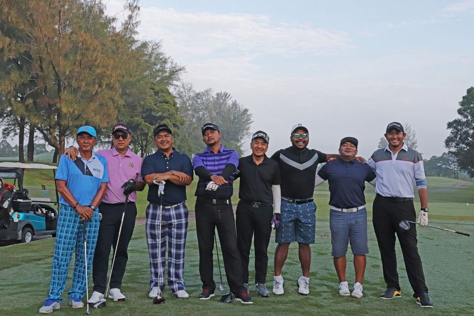 A group of gentleman posing for a picture at the golf filed 