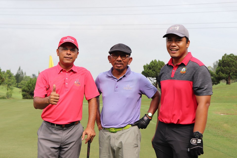 A group of 3 gentleman posing for a picture at the golf filed 