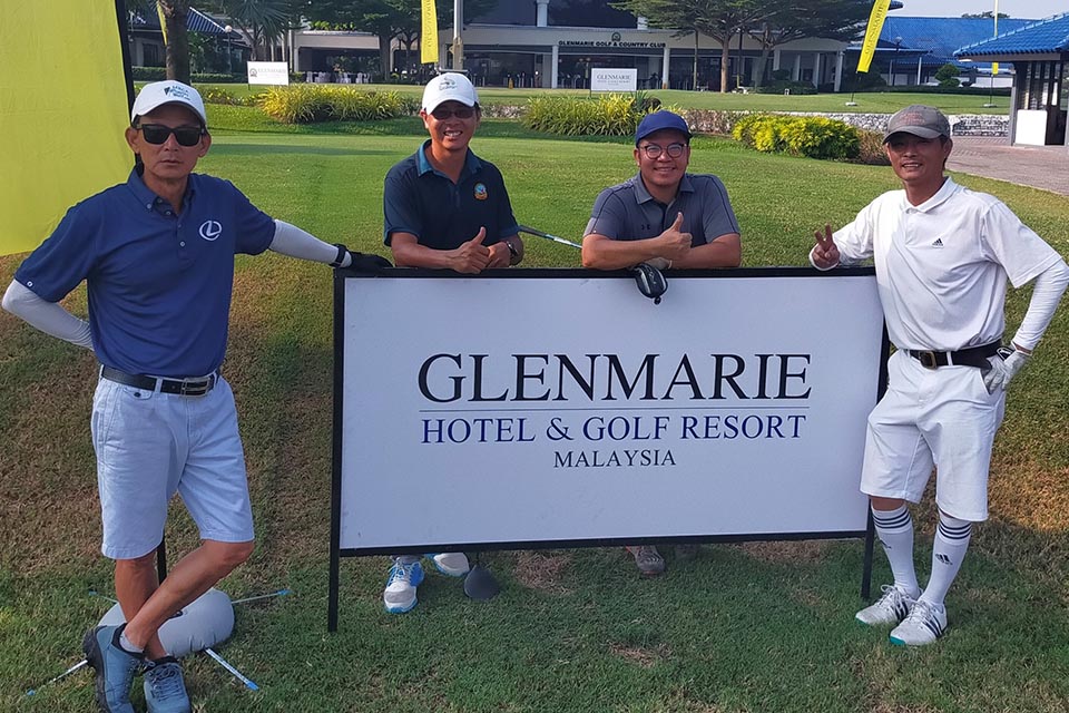 Four Men are Posing for a Photo Near the Glenmarie Name Board