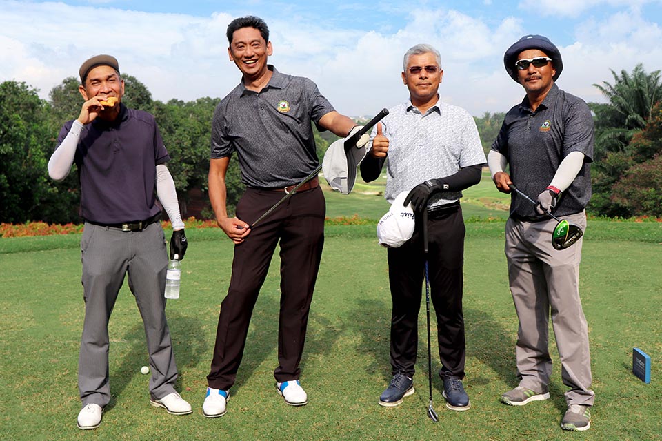 Four gentleman posing at the golf filed