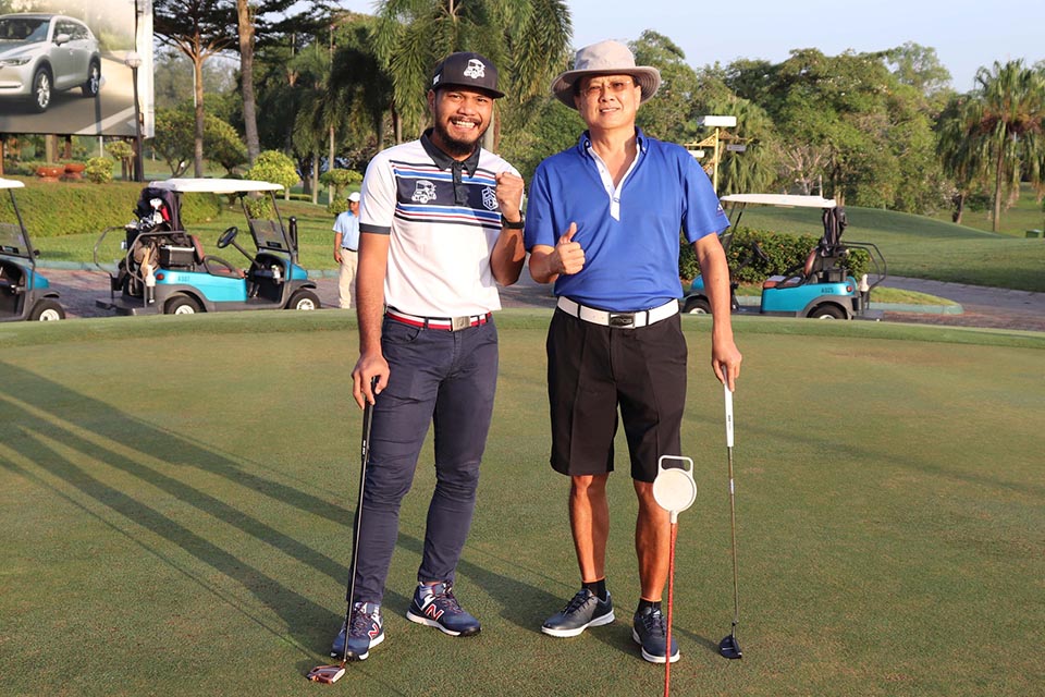 Two golf players posing for a picture at the golf field
