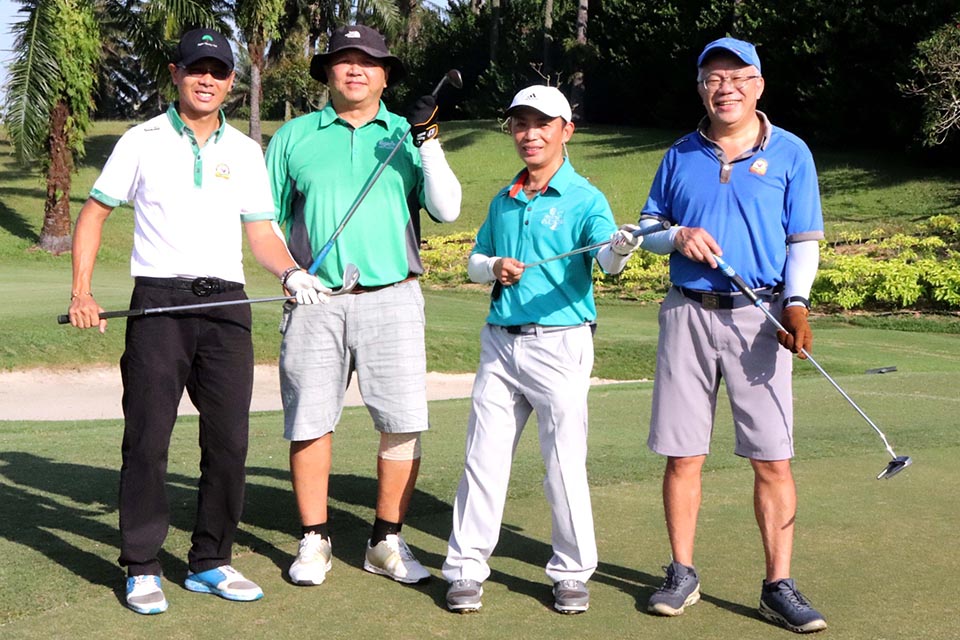 Four guests are posing for a picture with golf club at the golf course at Glenmarie