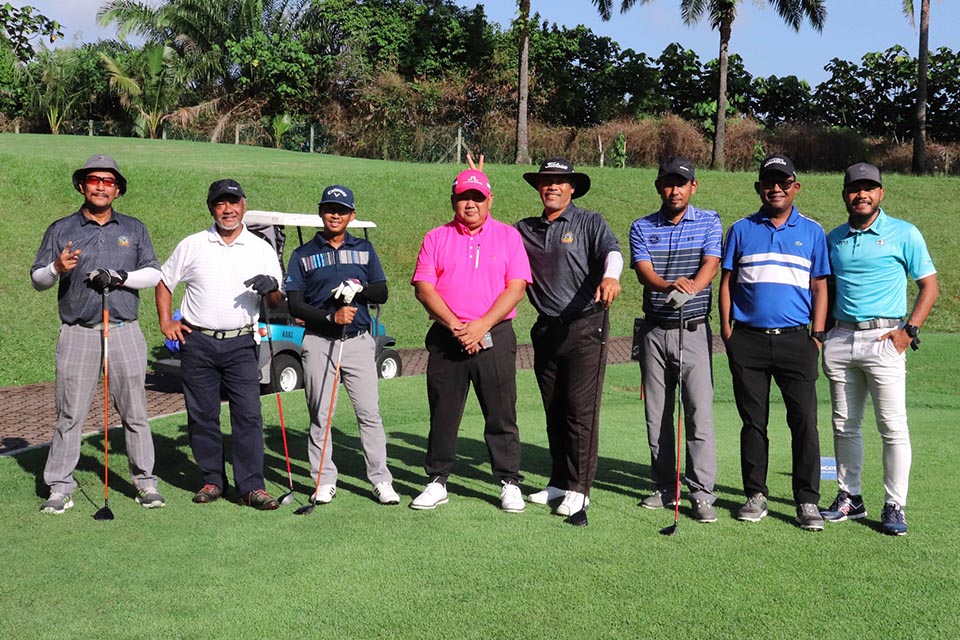 A group of gentleman posing for a picture at the golf filed 