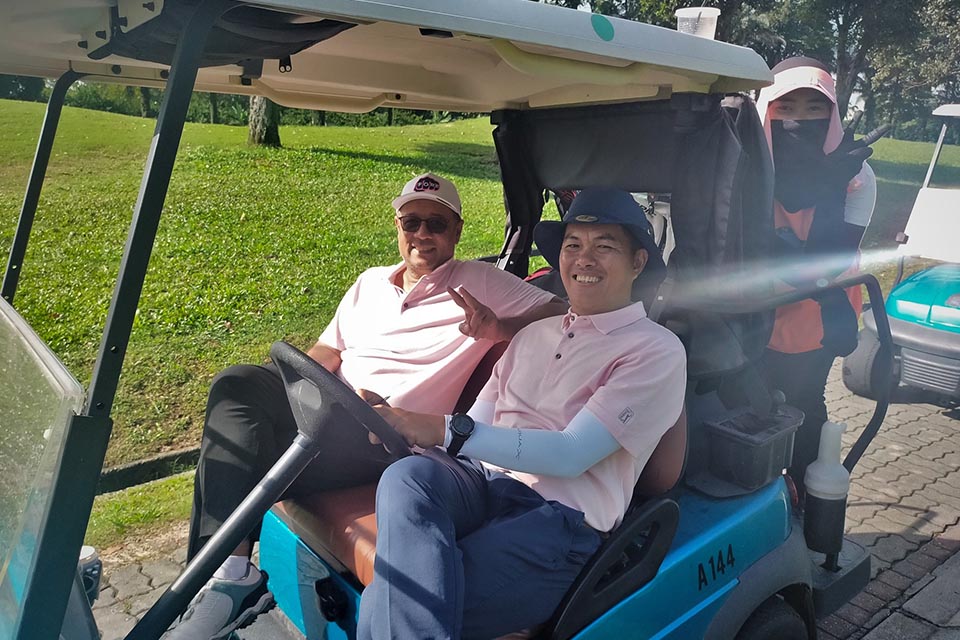 Two guests laugh in a golf cart at Glenmarie